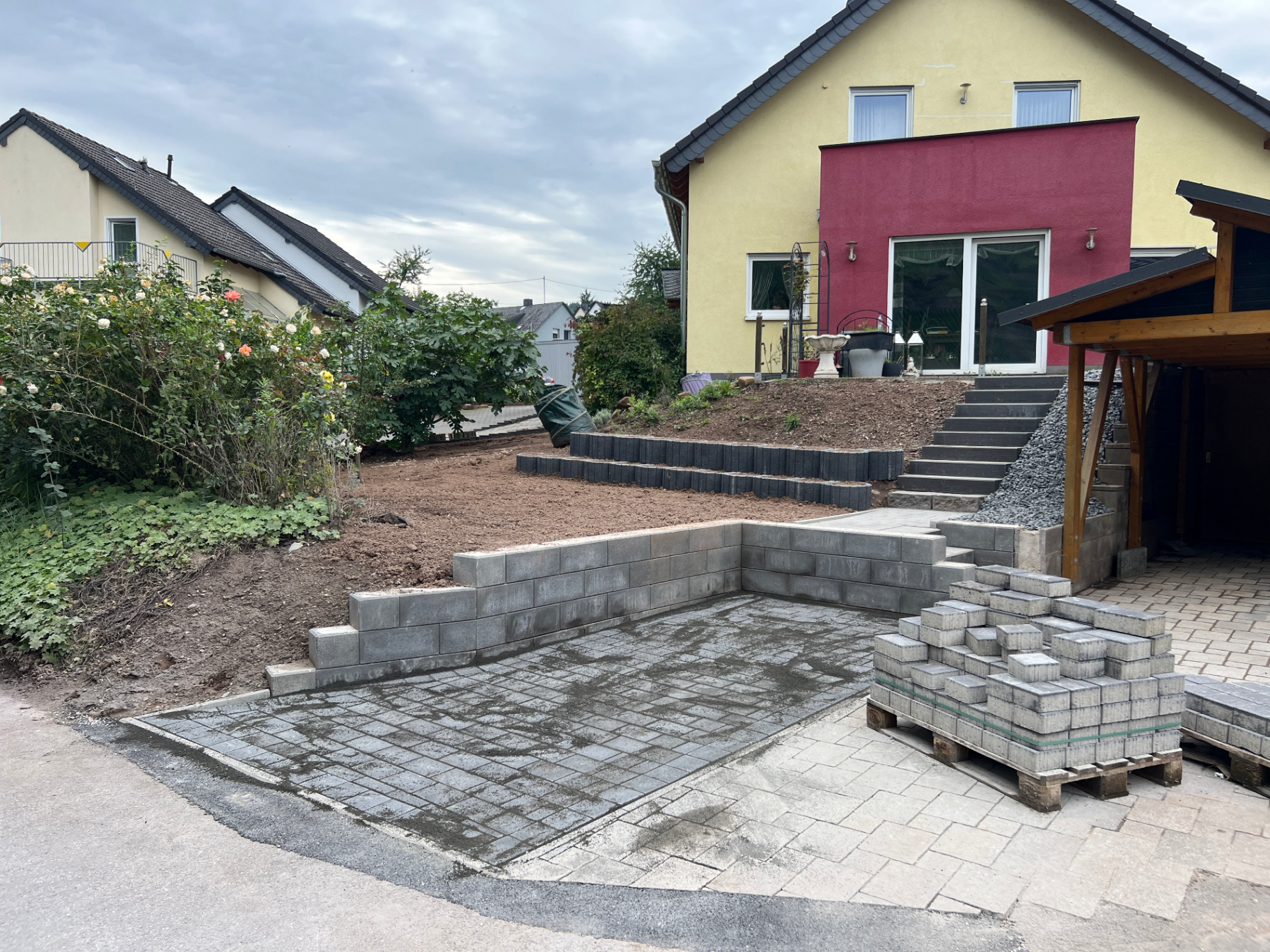 Garten- und Landschaftsbau mit neu gepflasterten Flächen, Stützmauern und Pflanzenbeeten